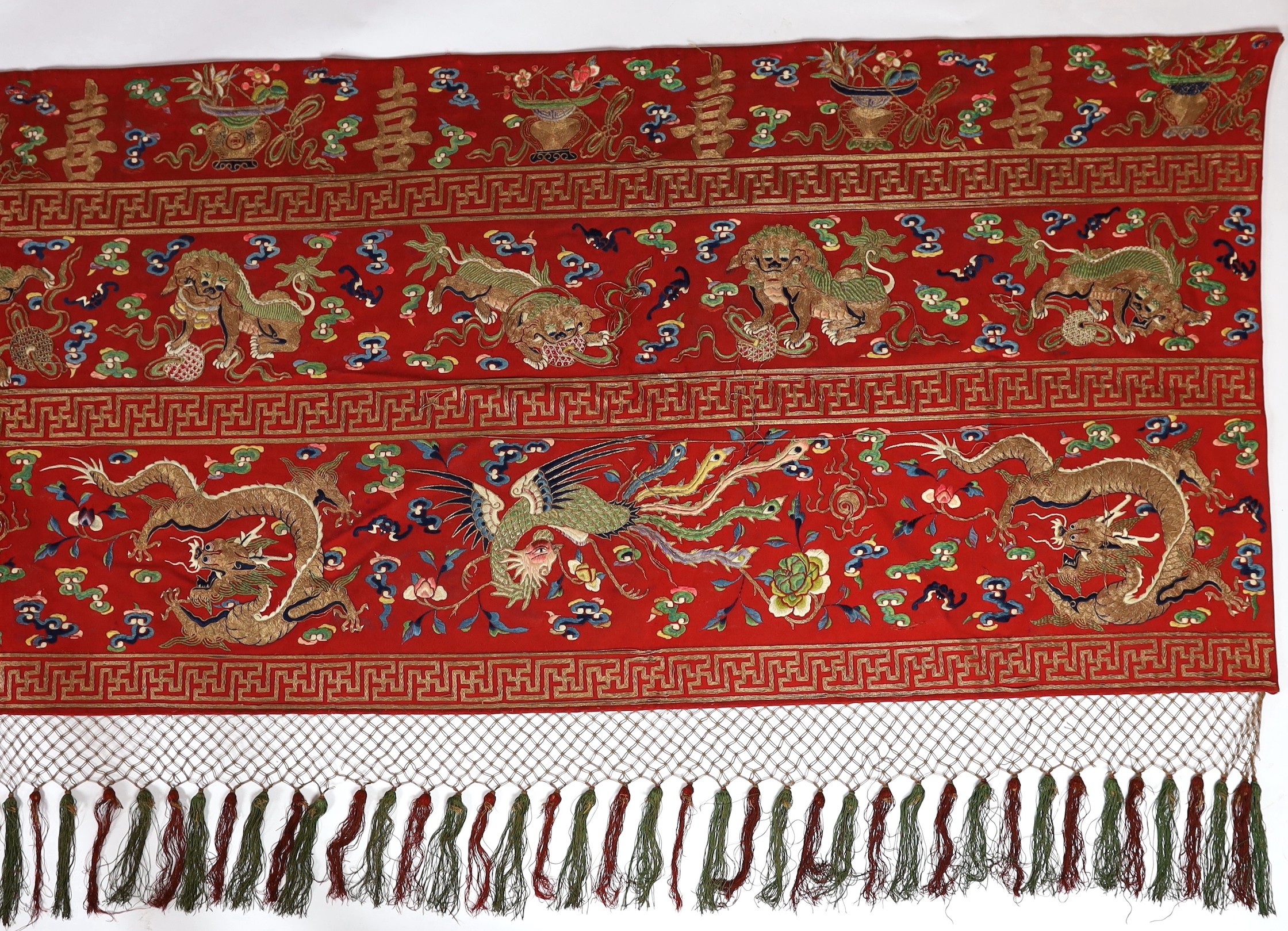 A Chinese embroidered silk ‘dragon, phoenix and lion’ panel or table frontal, late Qing dynasty, 117cm x 337cm